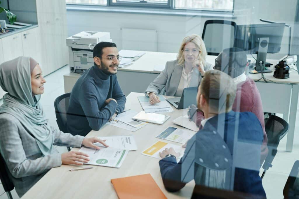 Professional business team collaborating in an office, illustrating compliant Employer of Record and payrolling services for growing businesses.